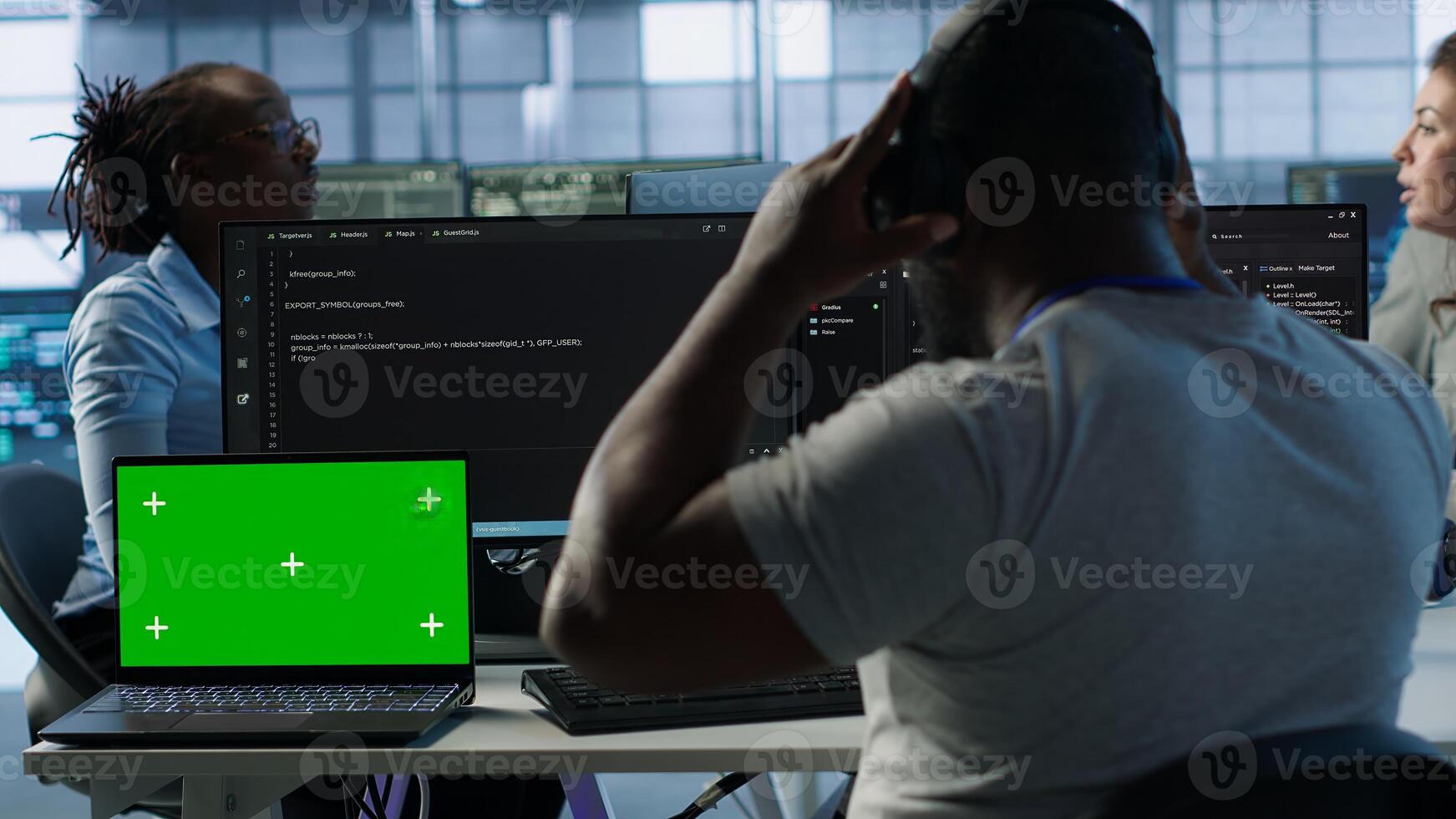 Isolated screen laptop next to programmer coding in server farm while listening music in headphones. Worker safeguarding hardware against unauthorized access with chroma key notebook, camera A photo