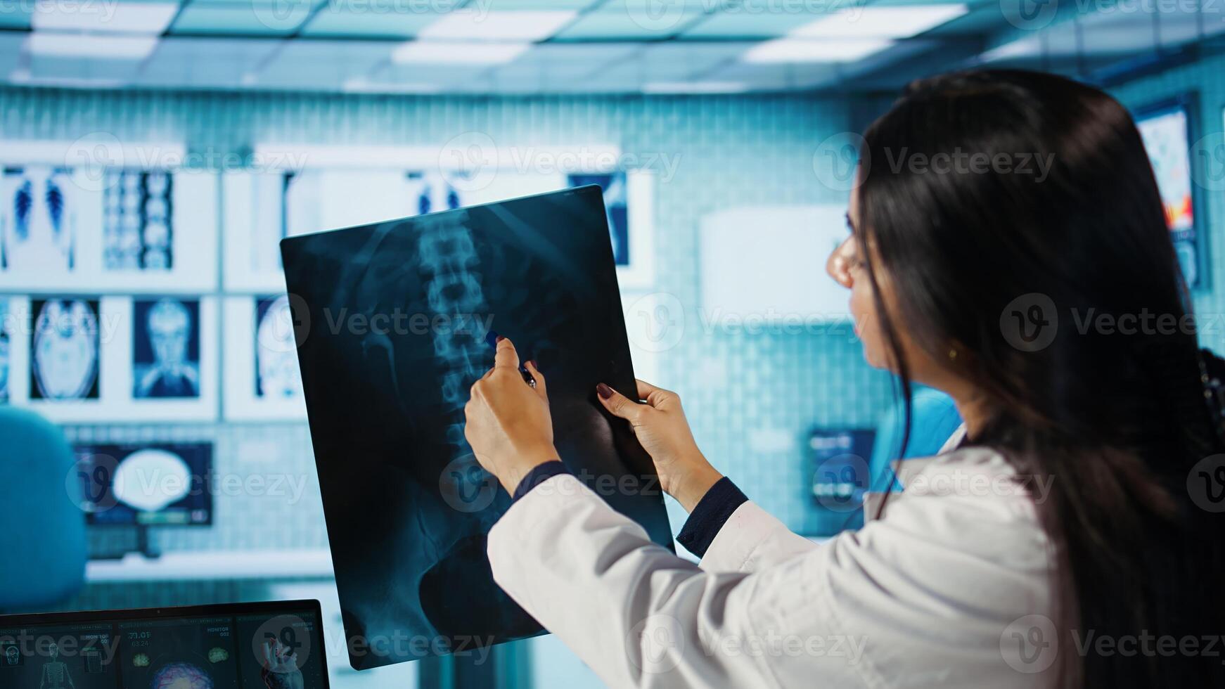Indian female specialist explains diagnosis through test findings with a young man in medical cabinet, doing scan interpretation at appointment with patient. Healthcare services. Camera B. photo