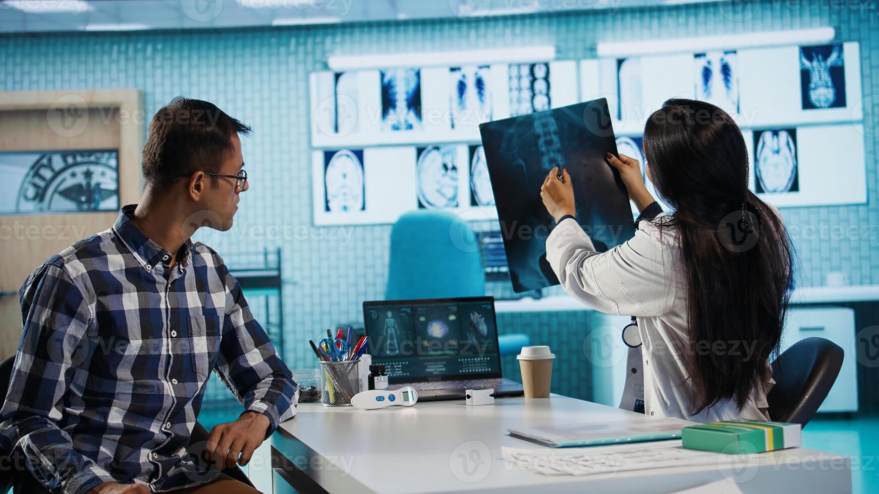 Indian medical staff and male patient engaging in a check up exam with diagnostic tools and test results for scan interpretation. Showcasing healthcare practices and research. Camera B. photo