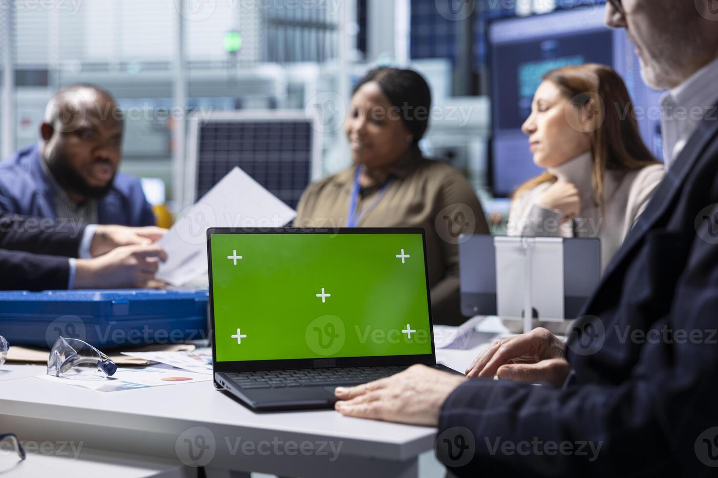 Shareholders and production plant manager analyzing sustainable manufacturing data using green screen laptop. Investors review documentation on chroma key notebook to evaluate investment profitability photo