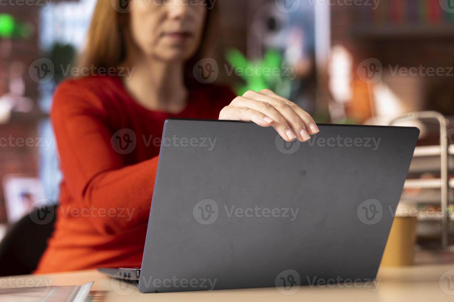 Smiling female freelancer browsing the web on her laptop in a modern apartment, demonstrating a lifestyle of independence, connection and productivity in a virtual workspace. Woman multitasking. photo