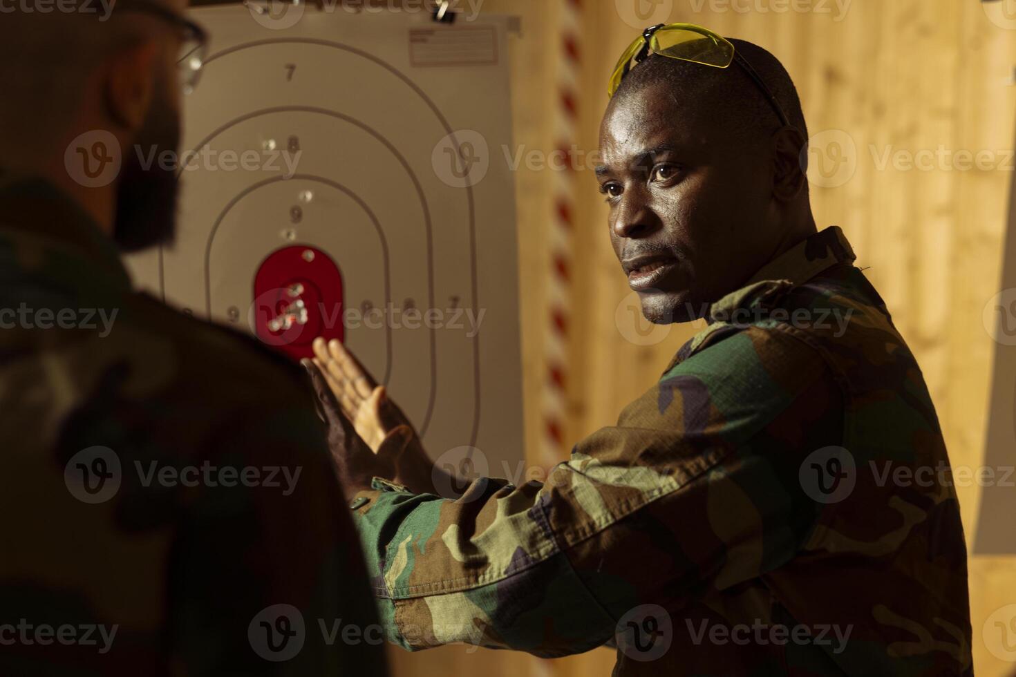 Army general at shooting range training soldiers to learn how to hit targets. Military commander demonstrating how to hit bullseyes, increase gun aiming efficiency during practice photo