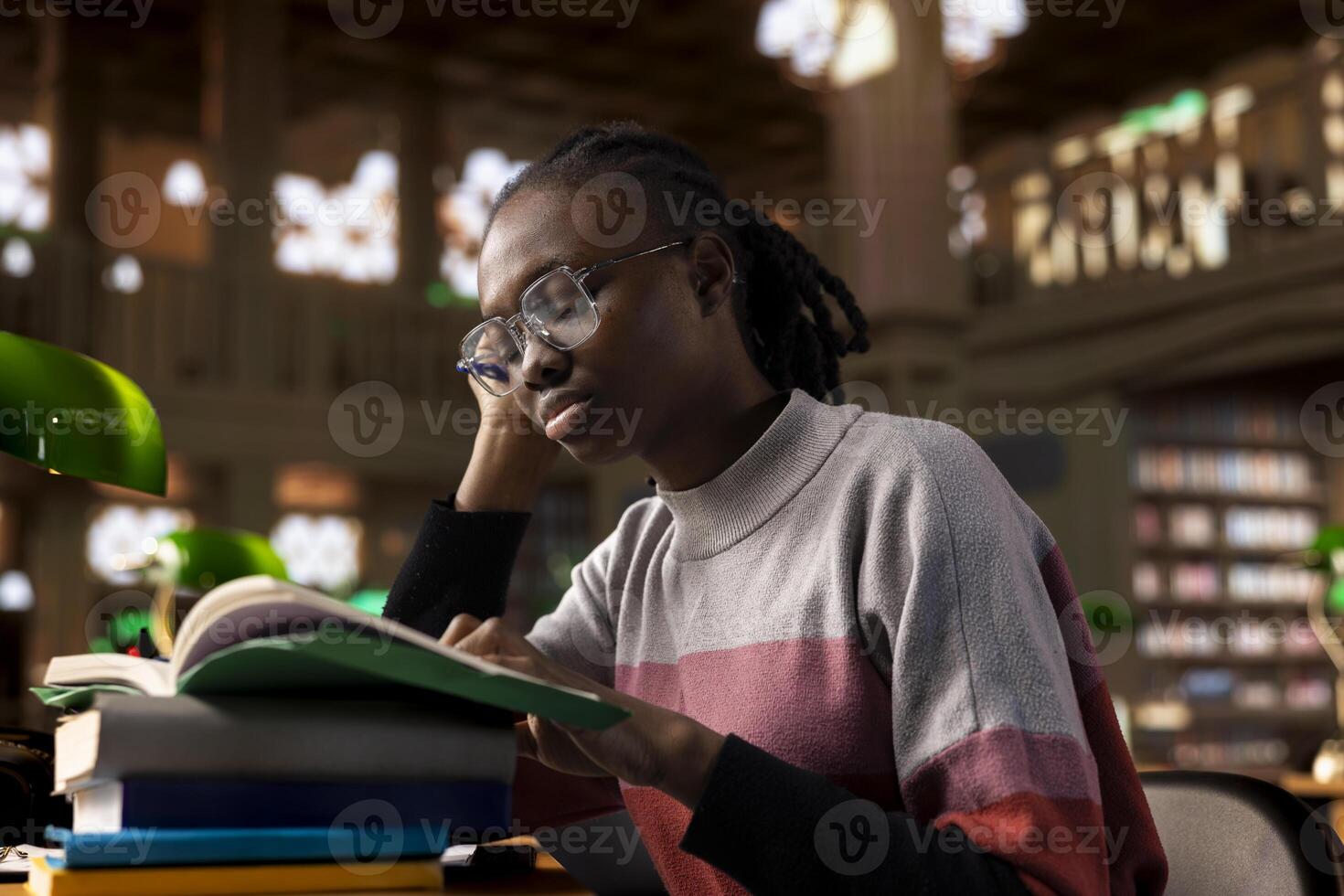 Sleepy young girl sleeping and dealing with burnout while she studies for college periodicals, working hard for her diploma with the highest grades. Exhausted student reading before exams. photo