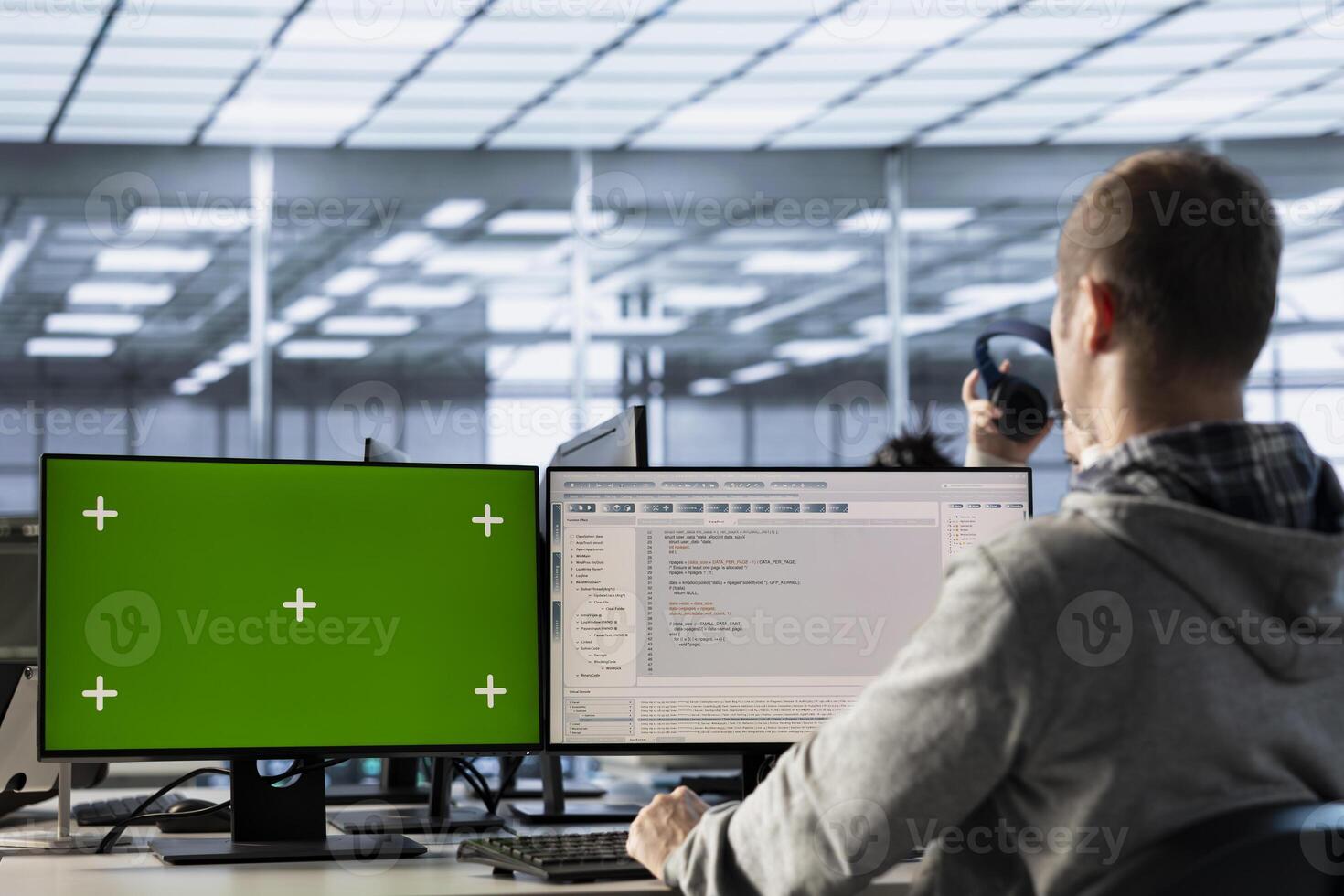 IT expert in server farm using green screen PC ensuring valuable data remains shielded from threats. Man safeguarding hardware against unauthorized access using mockup computer photo