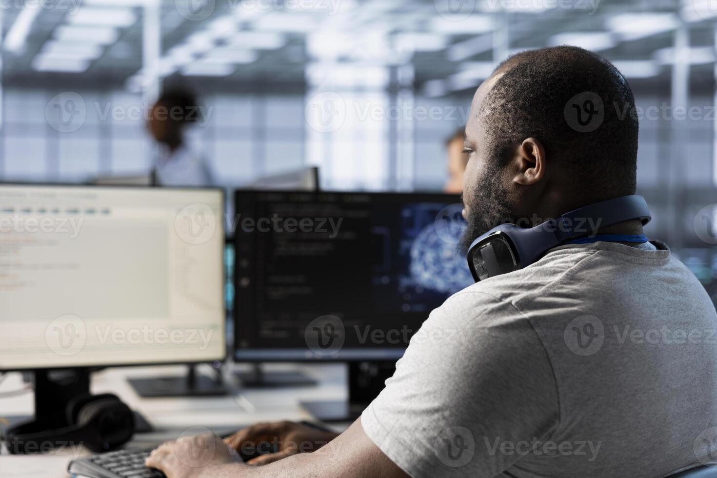Computer scientist using artificial intelligence technology to optimize data center performance. African american IT expert in server farm using AI tech to accurately forecast potential issues photo