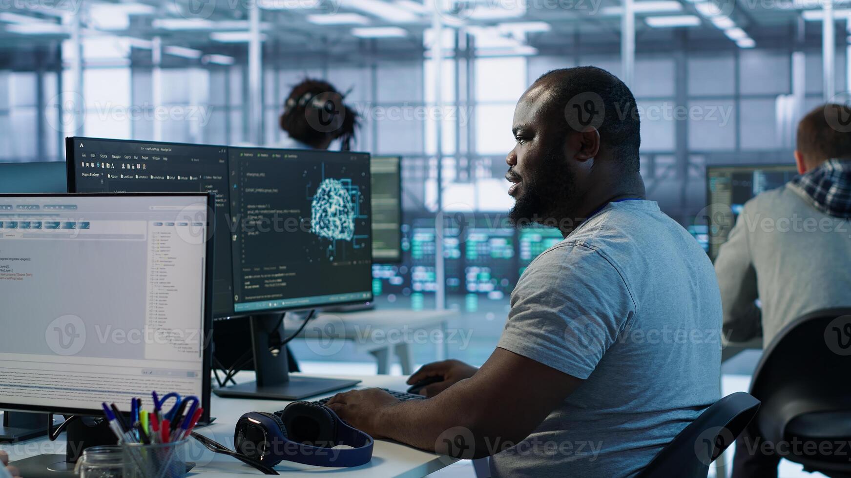 Engineer writing code and doing checkup on server room providing computing resources for different workloads. Man investigating data center mainframes using computer, camera A photo