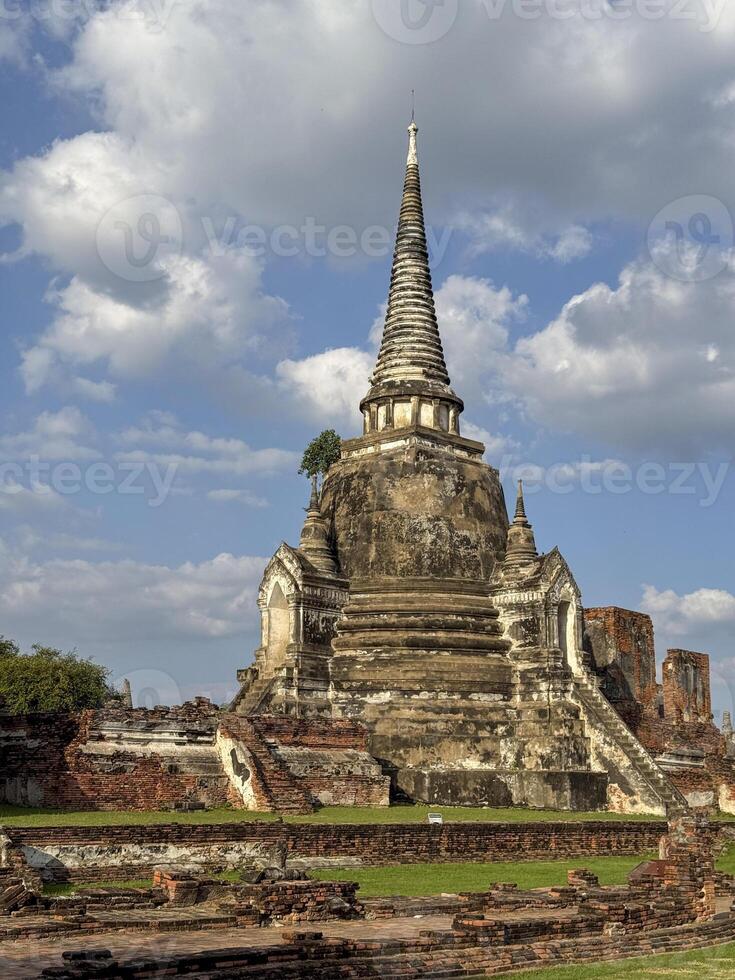 People visiting the famous Wat Maha That Buddhist temple landmark, peaceful sacred place of worship with ancient construction. Historical Thai heritage and culture, brick monument. photo