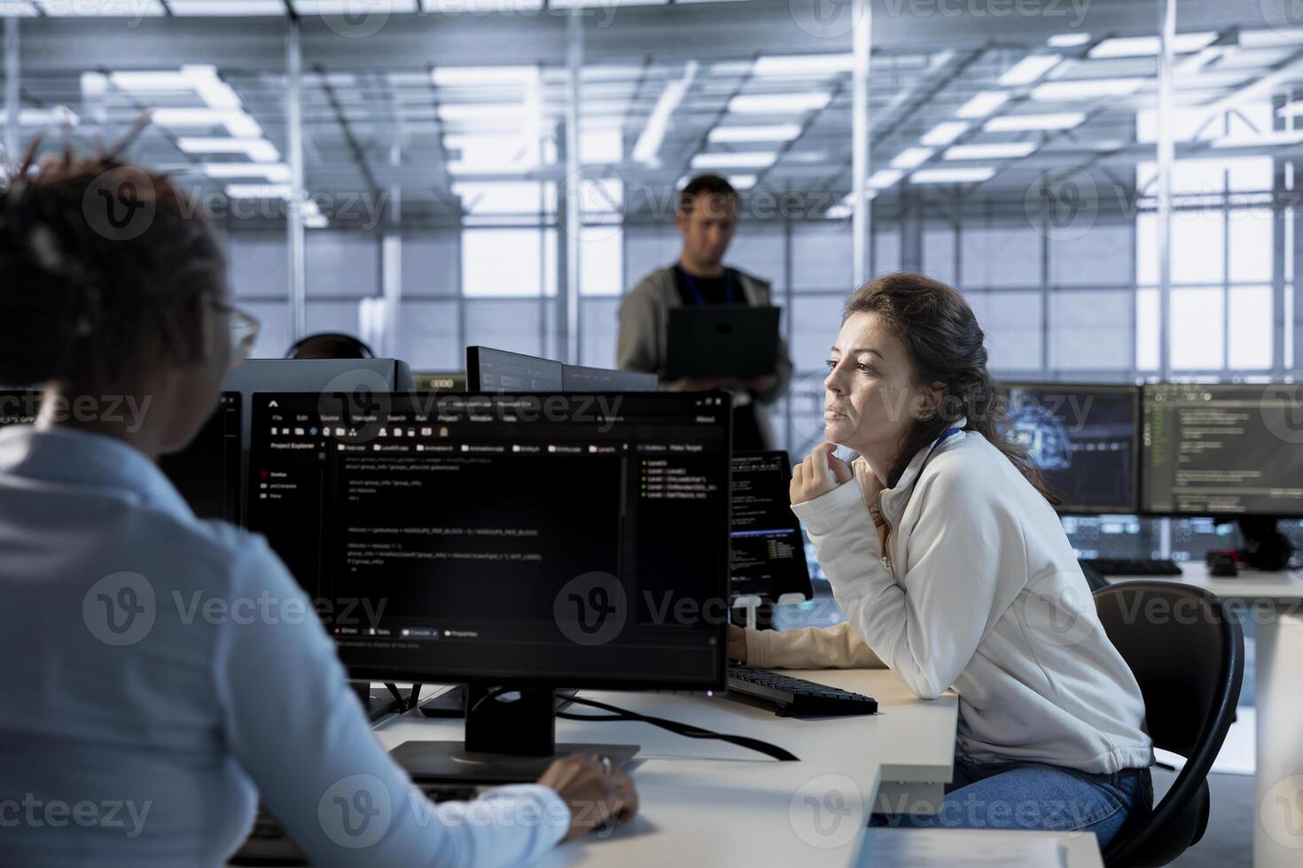 Data center computer scientist developing disaster recovery plans ensuring minimal downtime. Server room employee uses data analytics to monitor performance and predict future infrastructure needs photo