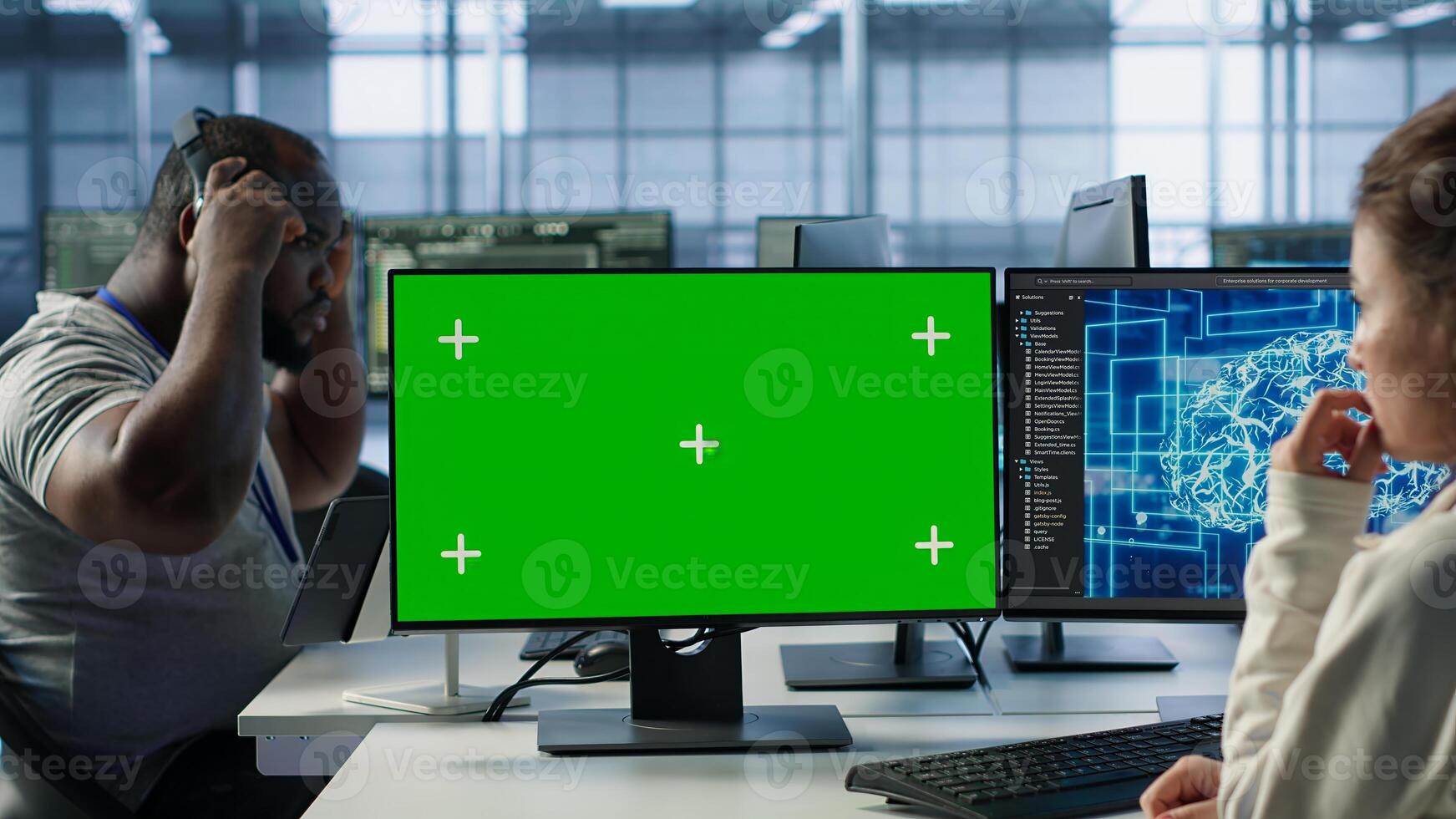 Employee working on green screen computer in server hub, using AI to process data. IT developer at chroma key PC updating servers controlling network resources using artificial intelligence, camera A photo