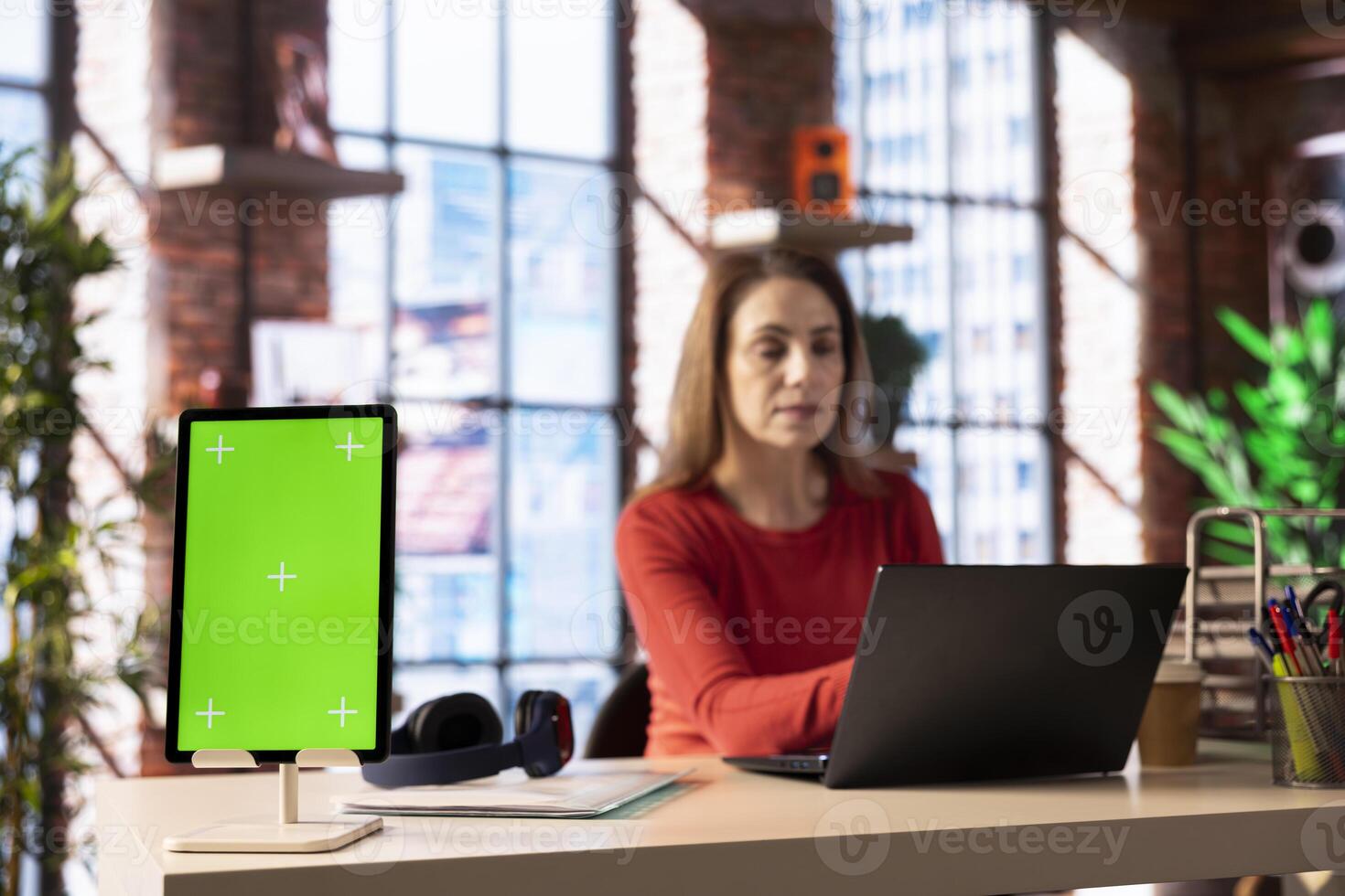Freelancer at home office does online research next to green screen and surfing the internet, utilizing a laptop for telework and staying connected in a digital world. Browsing the social media. photo