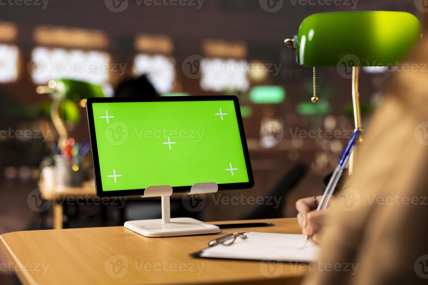 Young adult takes notes from study materials next to mockup copy space in the university library, consulting reliable sources as specialty books. Student enjoys practicing self learning. photo