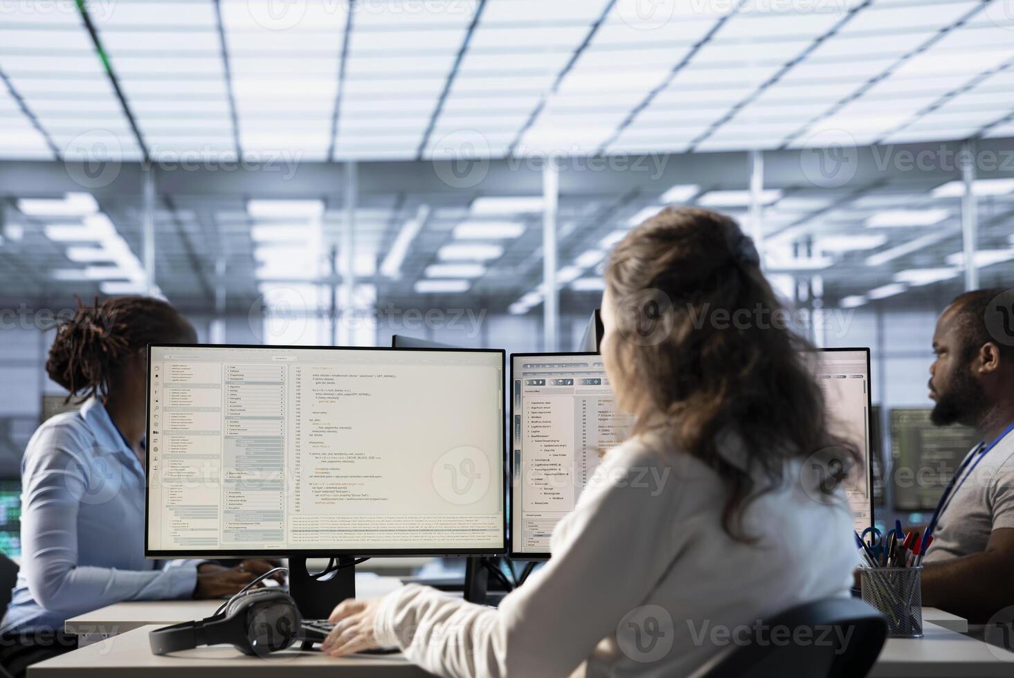 Engineer typing on computer in server hub, checking recovery plan, monitoring data center energy consumption, solving tasks. Technician inspecting rackmounts in data center photo
