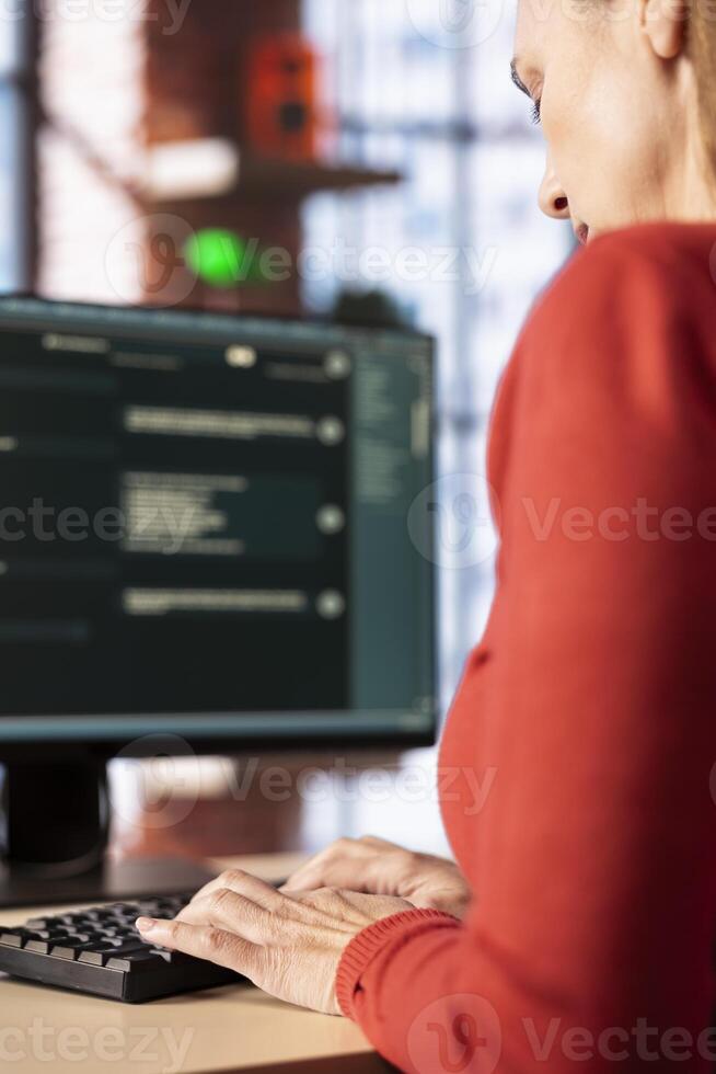 Mature woman interacting with a virtual assistant on her computer at home office, responses and smart automation to improve online communication. Data driven solutions. photo