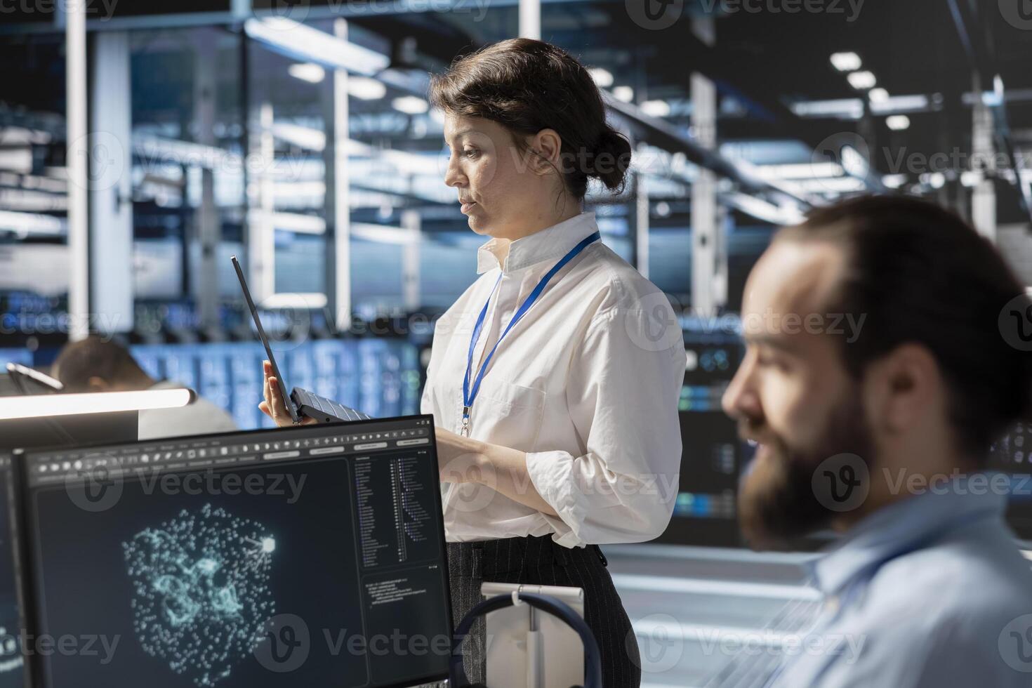 Admins using computer in data center office, managing server virtualization, running scripts. IT employees using programming language on PC in server room, finetuning network protocols photo