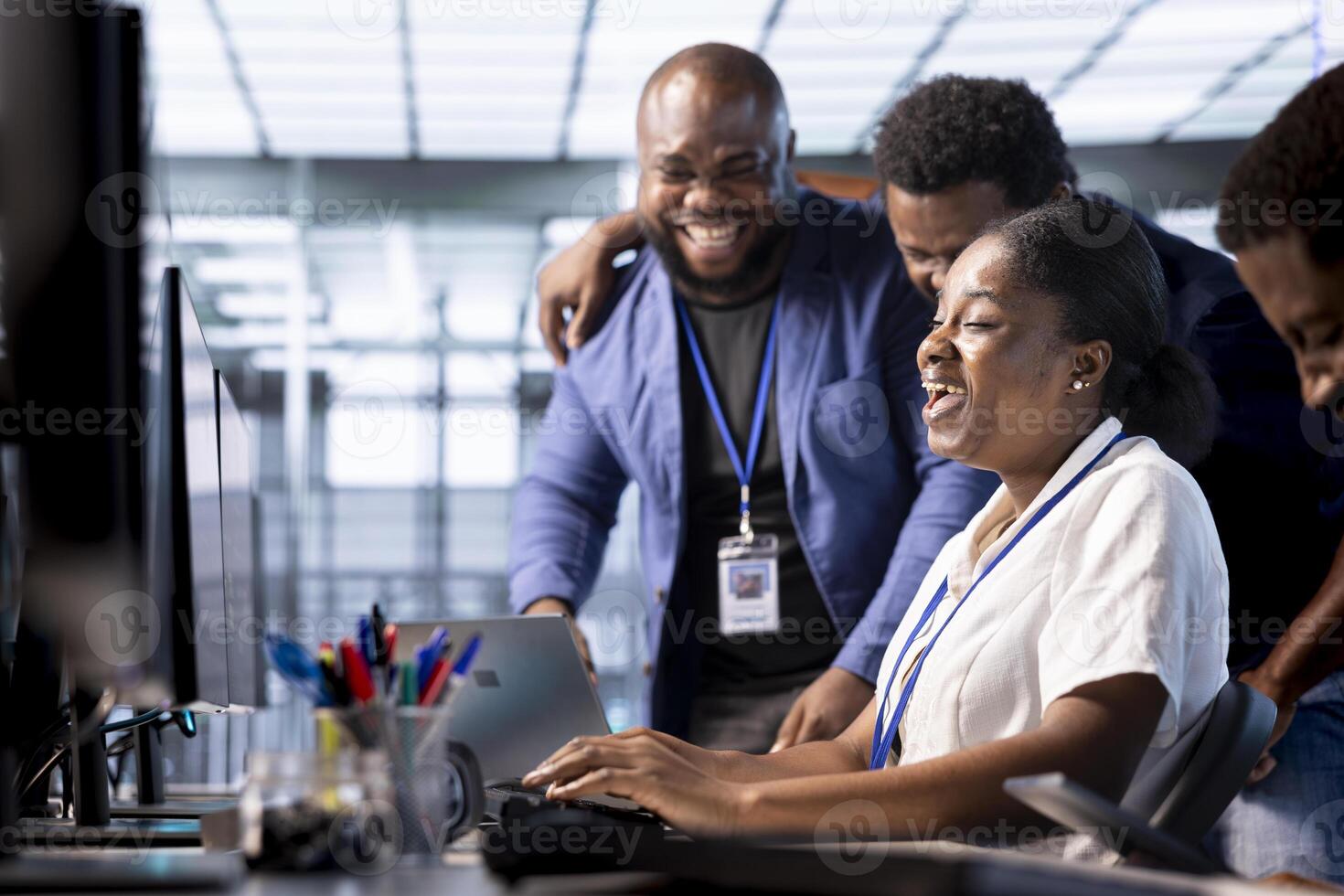 Team of happy engineers laughing, enjoying each other company while working in server farm workplace. Jolly coworkers having fun together during job break in data center office photo