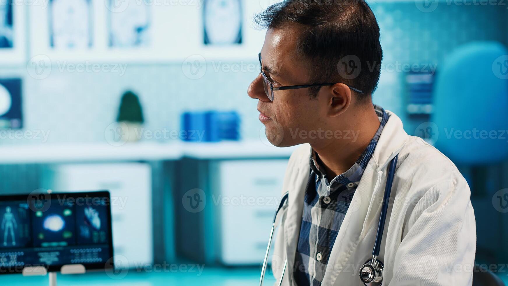 Indian healthcare expert sharing medical expertise with a patient in clinic, reviewing x ray scans and MRI diagnostics to focus on accurate treatment and recovery. Insurance check up. Camera A. photo
