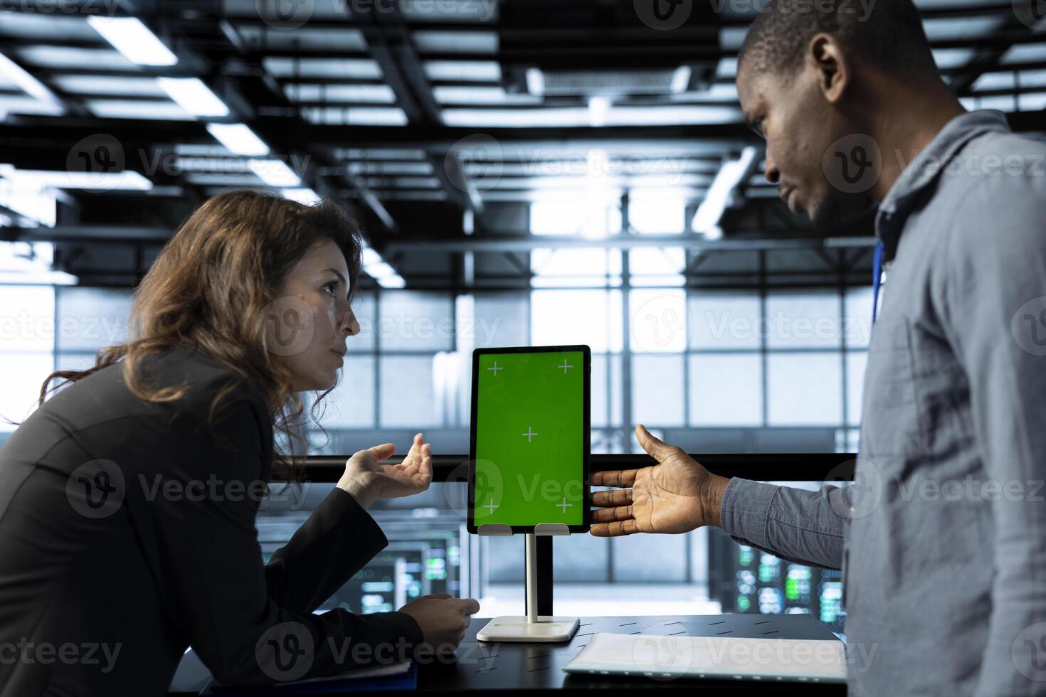 Programmers in data center brainstorming, using mockup tablet, observing analytics, reviewing equipment health. Team of server hub IT specialist use isolated screen device, adjusting system parameters photo