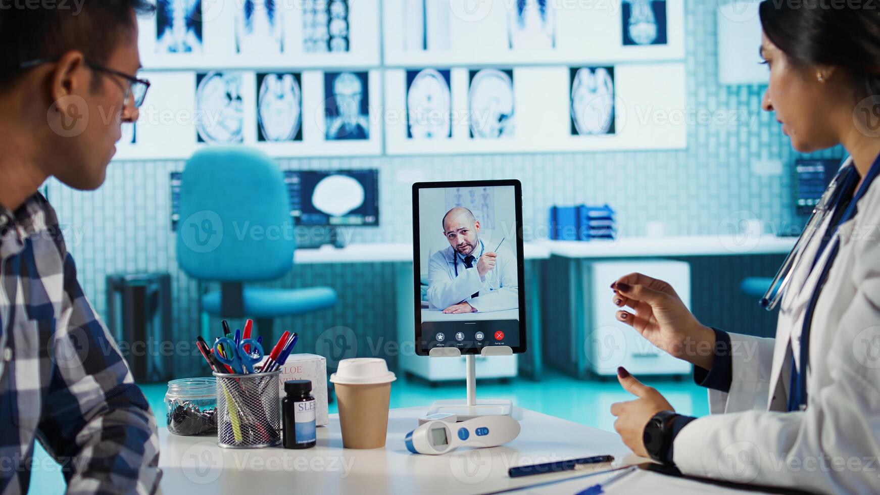 General practitioner discussing with a doctor on conference call, reviewing test results diagnosis and sharing records. Indian medic searching treatment against disease, telehealth. Camera B. photo