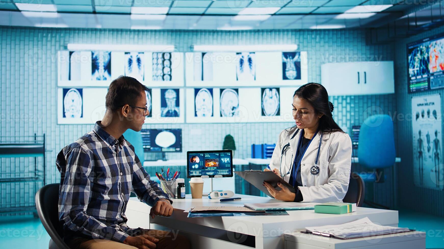 General practitioner consulting patient and reviewing x ray test results, utilizing technology for analysis and care management in a medical environment. Healthcare provider. Camera B. photo