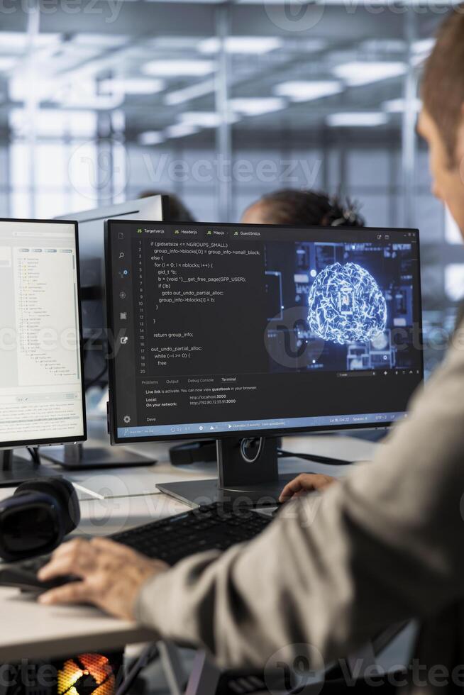 Admin implementing artificial intelligence cybersecurity measures to protect data center. Server hub AI professional monitoring and analyzing metrics with device to enhance operational effectiveness photo