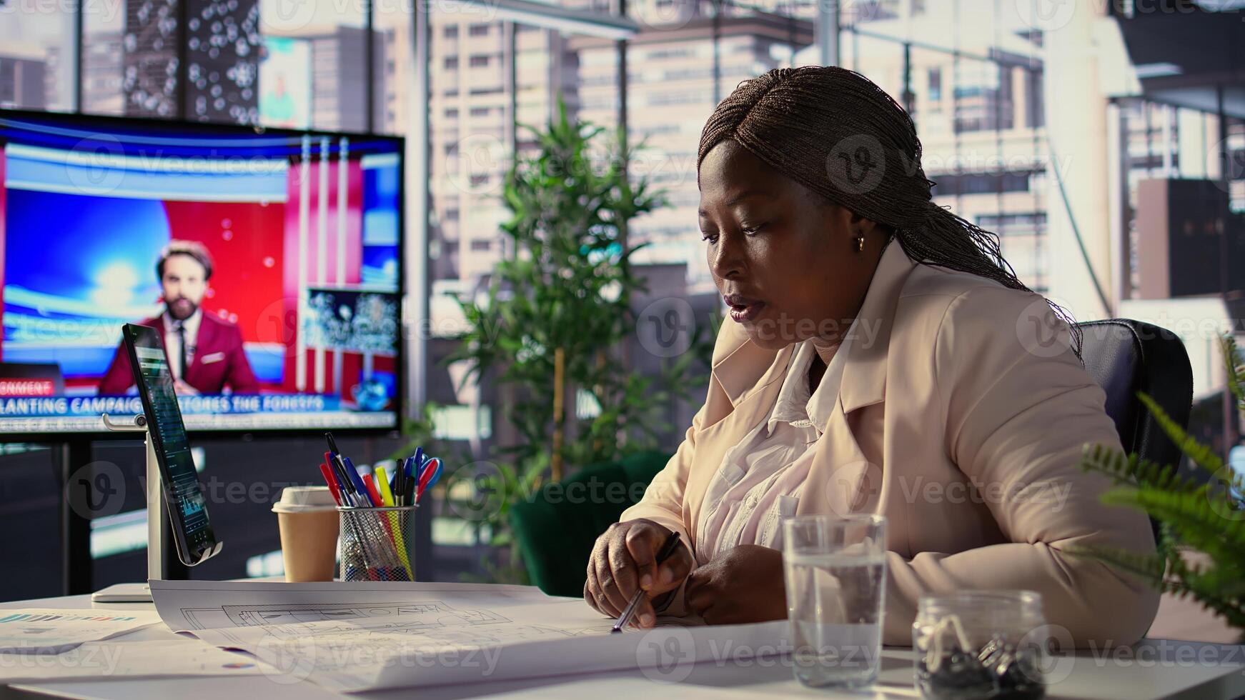 Black female director evaluating architecture blueprints for new office space layout, relocate her startup. Entrepreneur conducts an office hunt, development for strategy planning. Camera B. photo