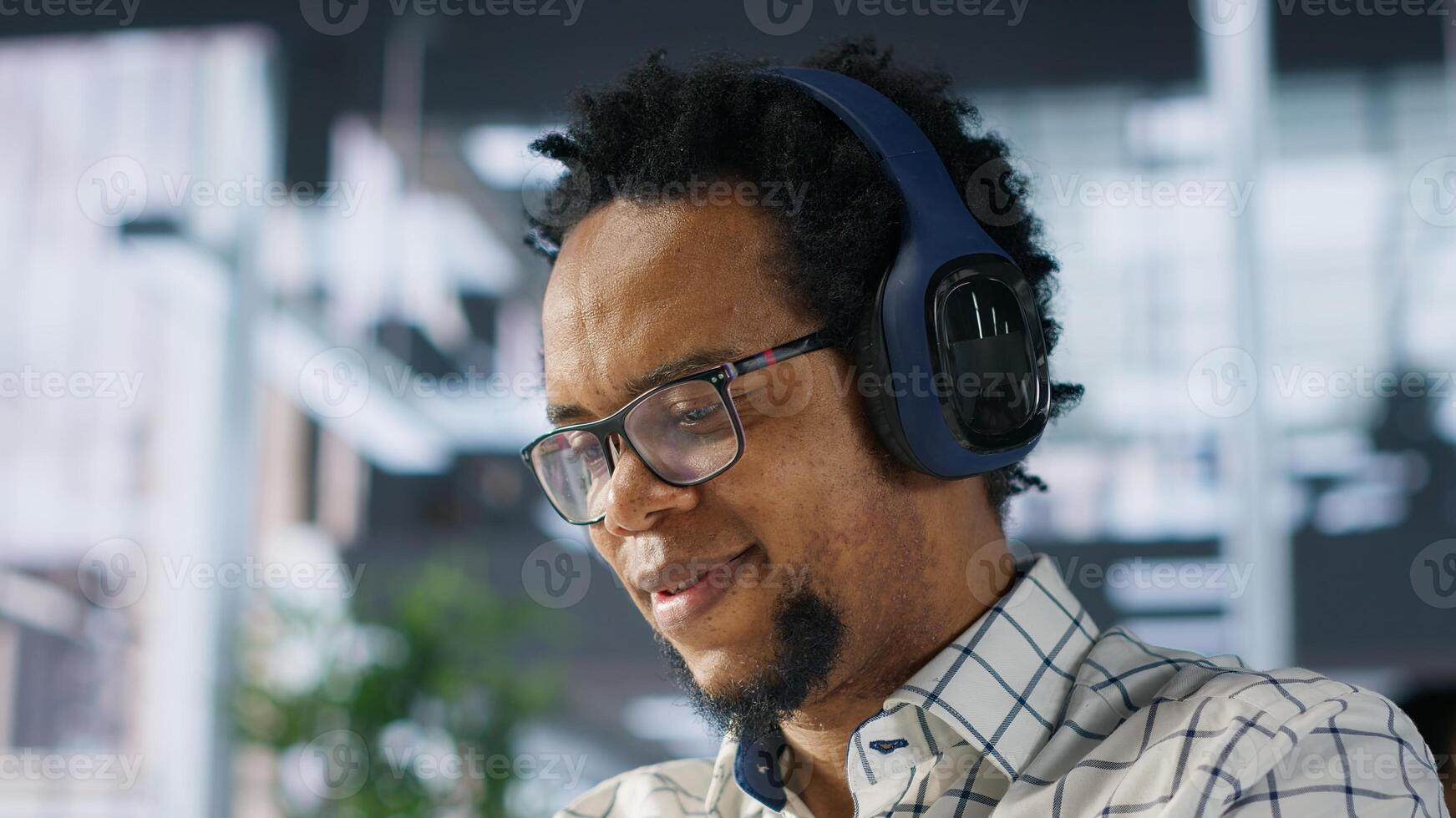 Executive assistant at a multinational company works with music on headphones, multitasking on business project. Professional uses data to manage operations and ensure successful outcome. Camera A. photo
