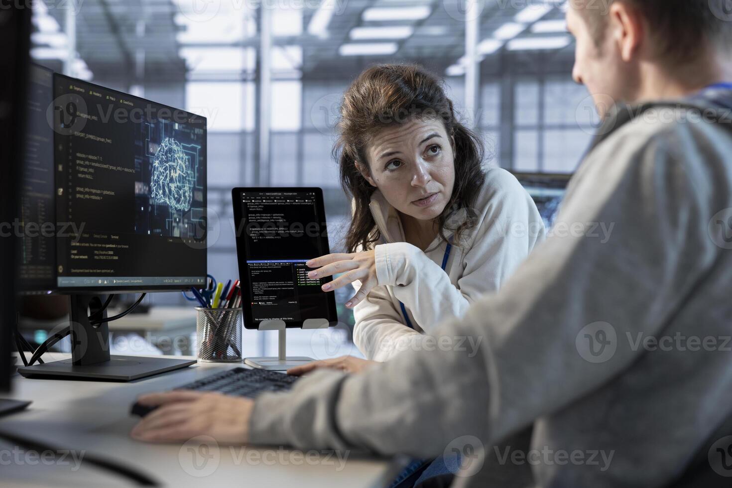 Software developers using tablet in data center, coordinating deployment of server architecture, improving data processing speed. Server hub IT workers configuring and testing hardware using device photo