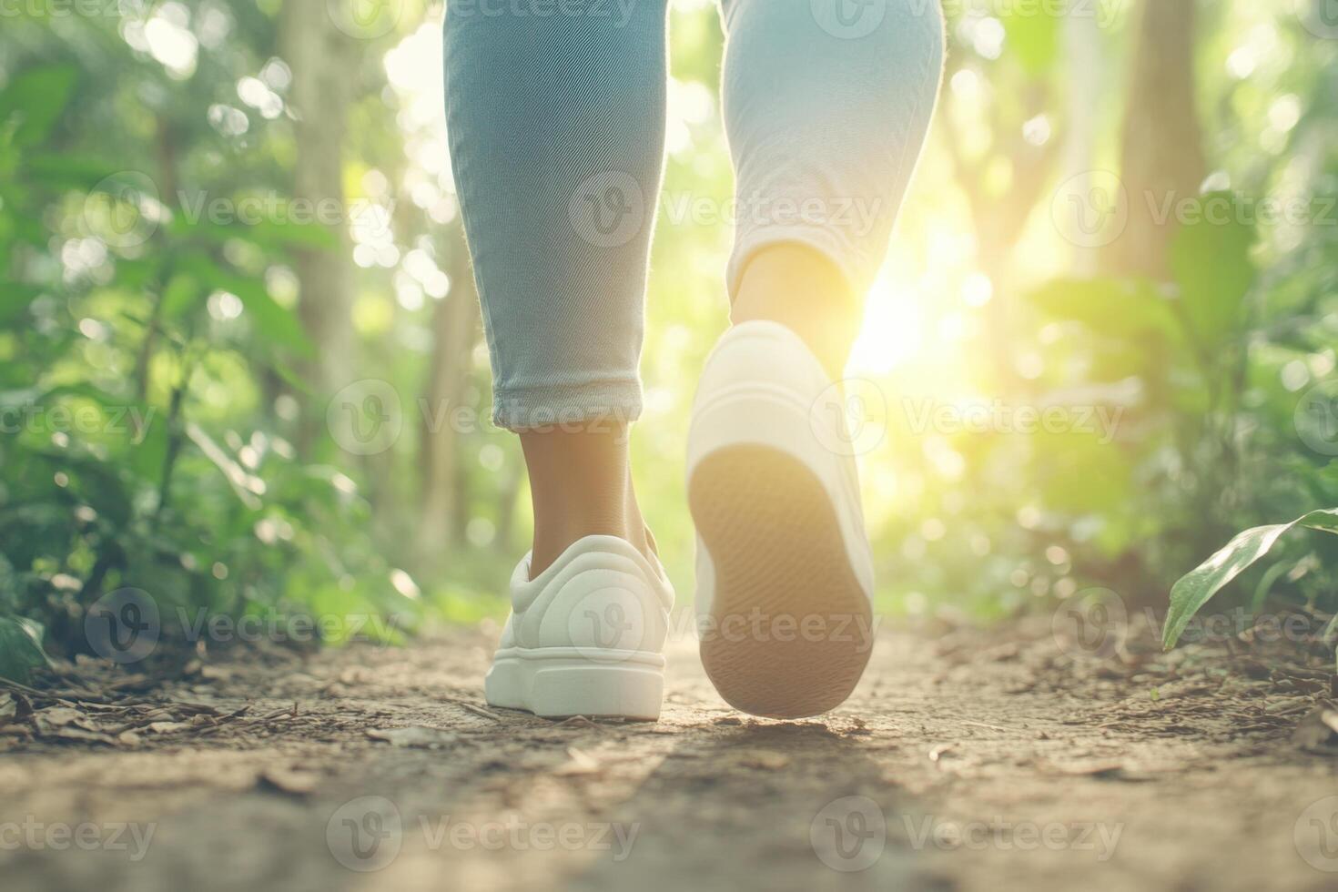 Young Black woman walks along a forest path surrounded by vibrant greenery and sunlight in serene nature setting photo