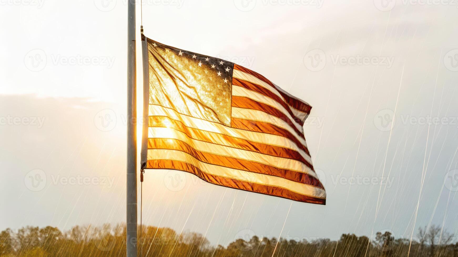 Flag waving under rainstorm at sunset capturing wet fabric illuminated by warm light and sparkling raindrops photo