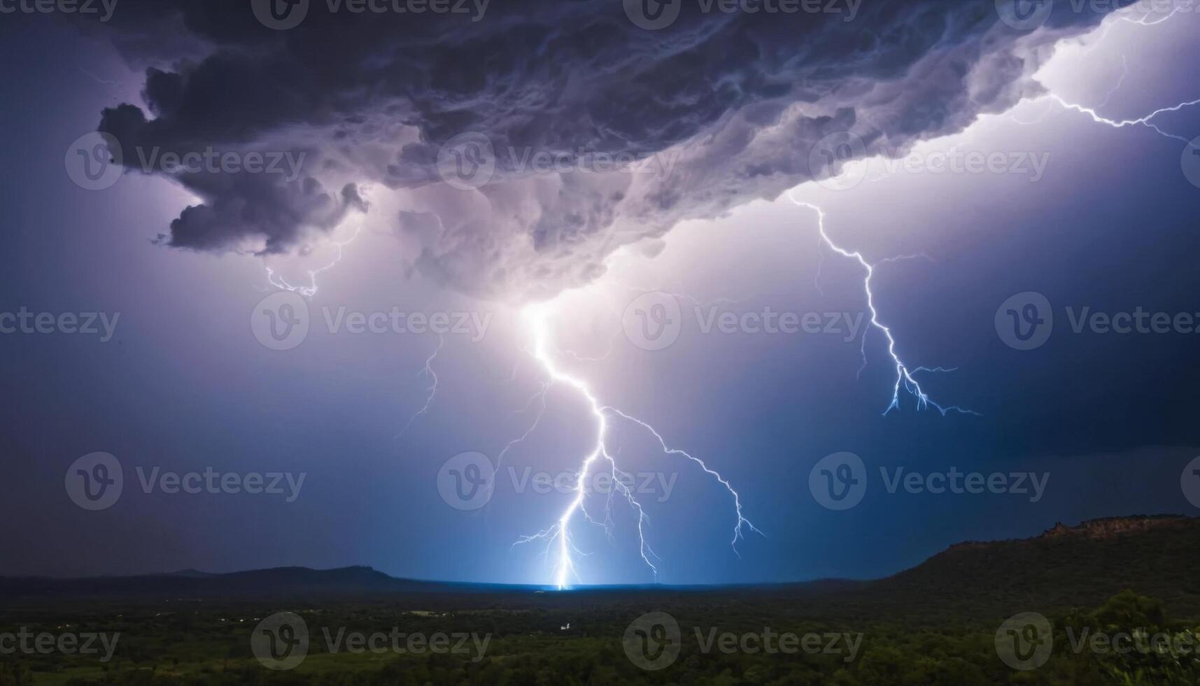 Dramatic Lightning Strikes Down from Dark Storm Clouds Over an Open Landscape with Distant Mountains and Flash of Light photo