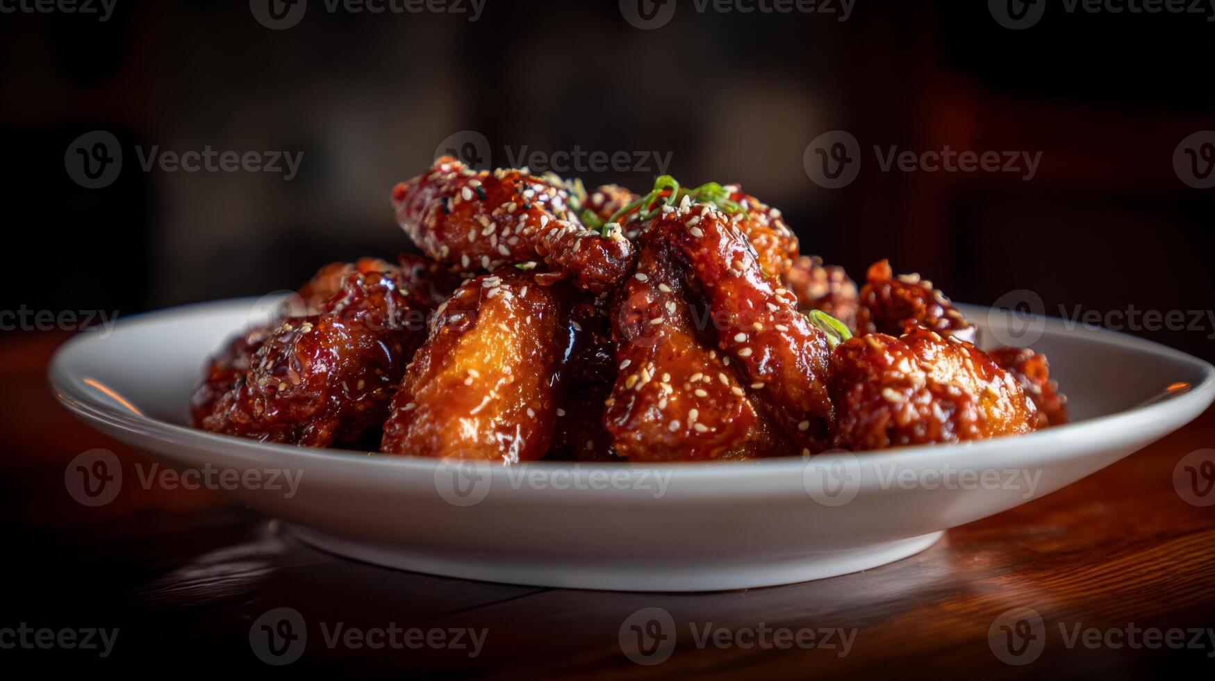 Delicious and Crispy Chicken Wings Glazed in Sweet Sauce Garnished with Sesame Seeds and Green Onions on a White Plate photo