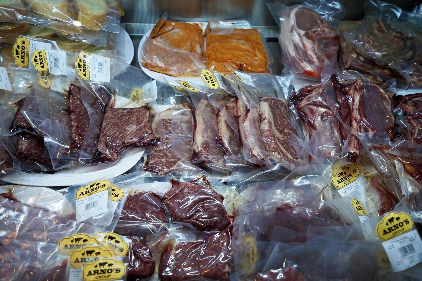 Packages of dry aged beef, Kurobuta pork and seafood steak displayed on shelf photo