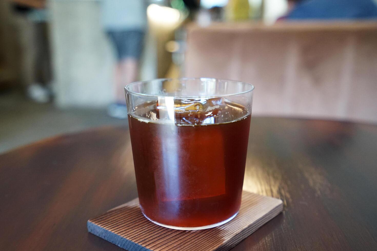 Close up glass of iced black Americano coffee on wooden table photo
