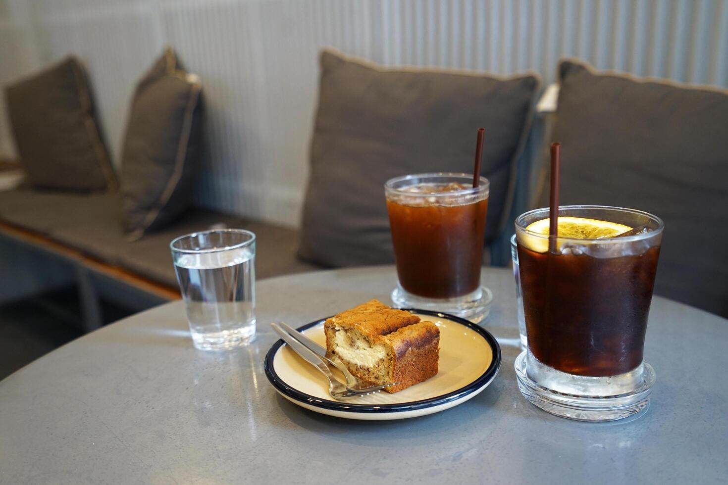 Close up lemon poppy seed cake served with iced black coffee photo
