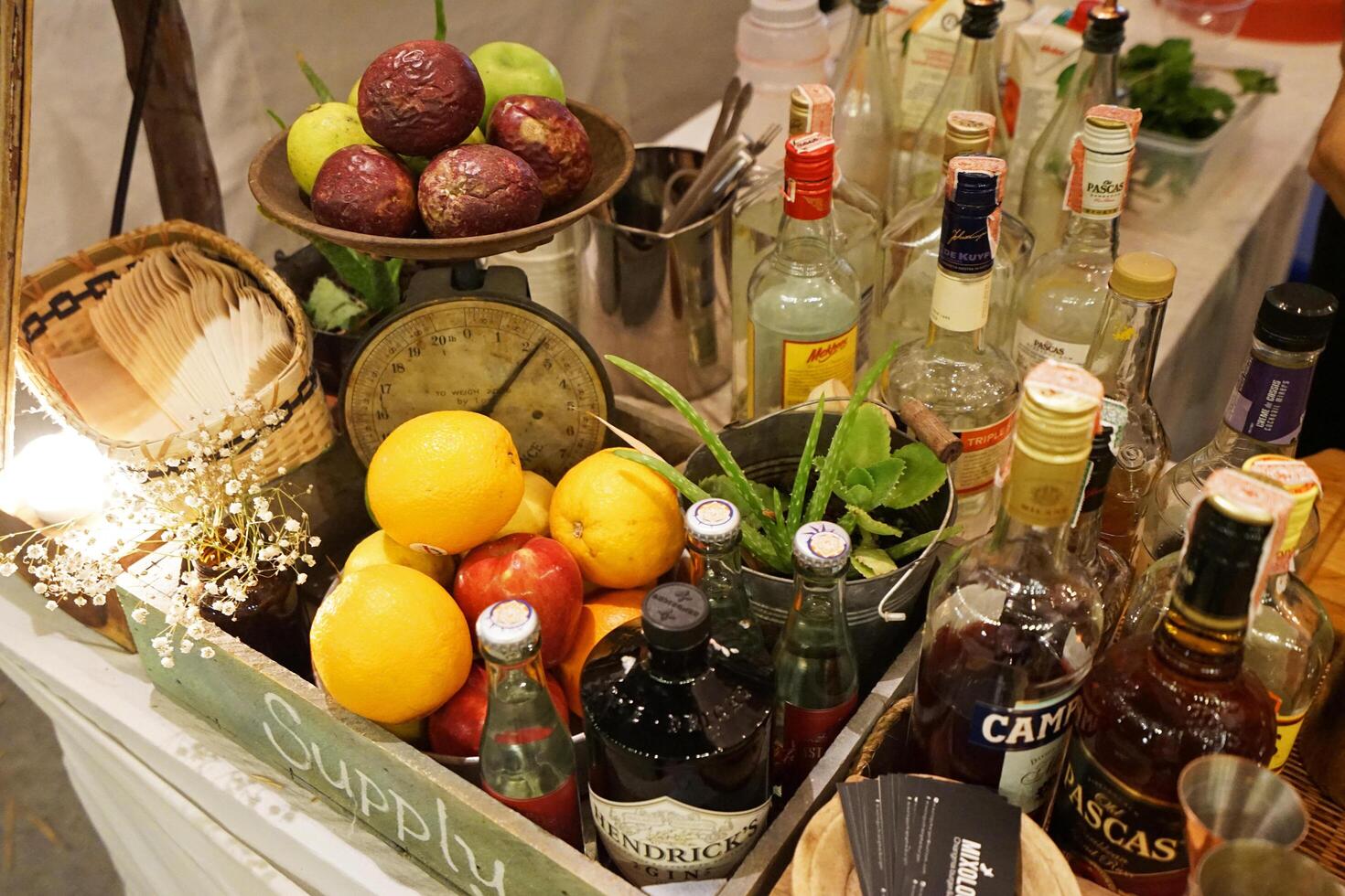 Close up colorful citrus fruits prepared for cocktail and alcohol beverage drink with bottles of wine and whiskey photo