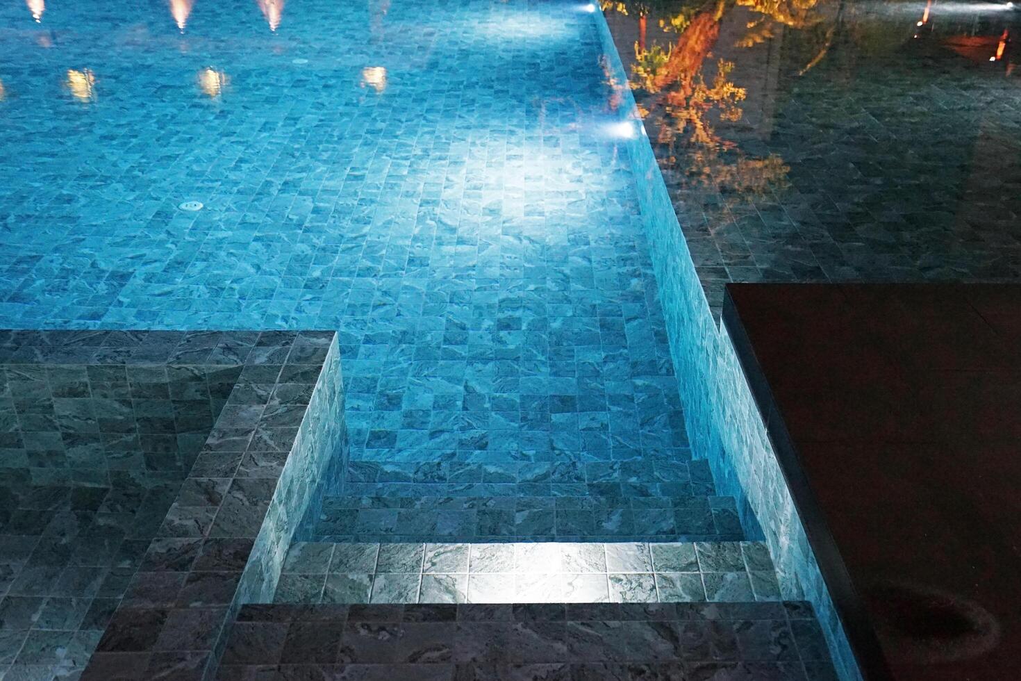 Exterior architecture and decoration design of Public swimming pool with lighting at night photo