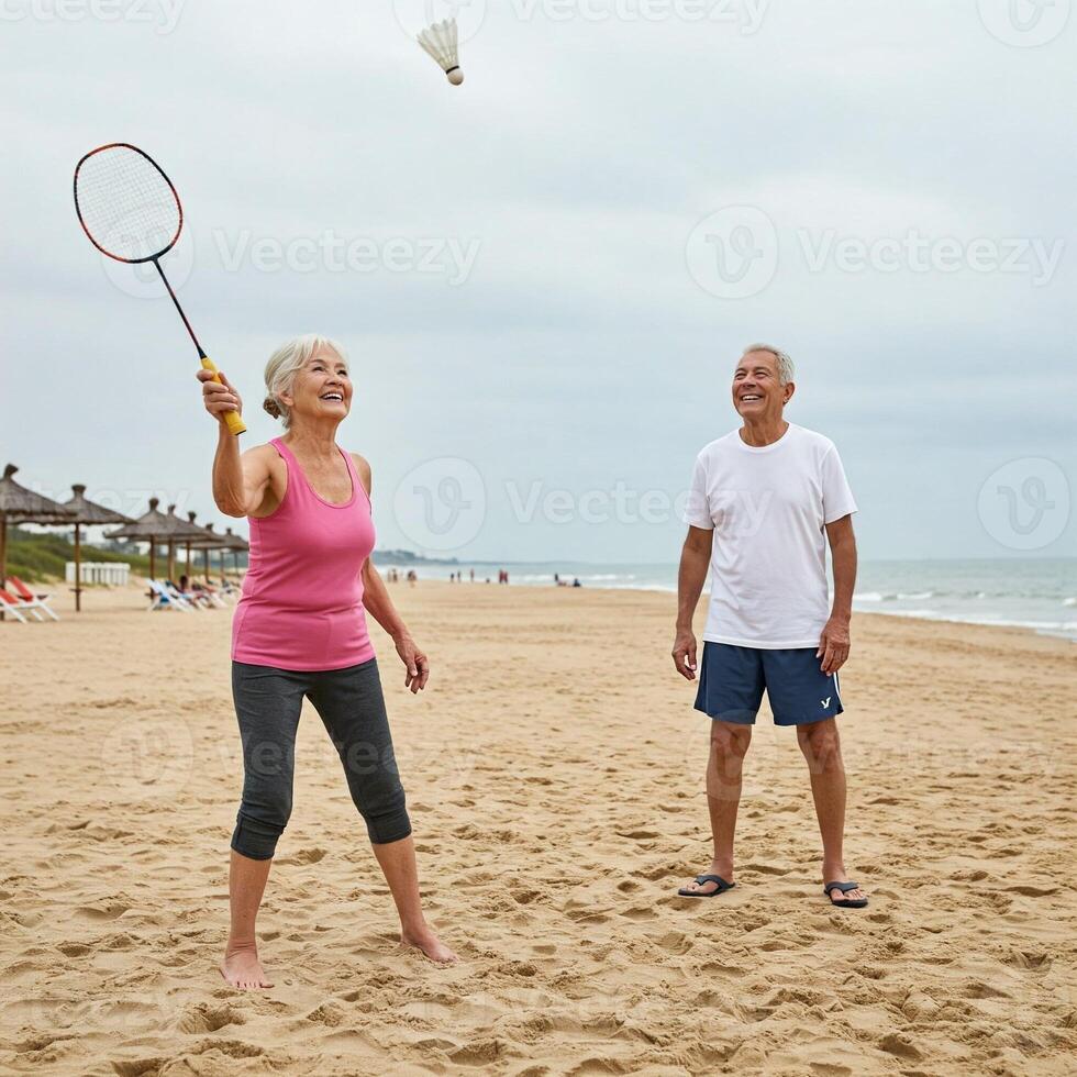 An older couple playing badminton on the beach photo
