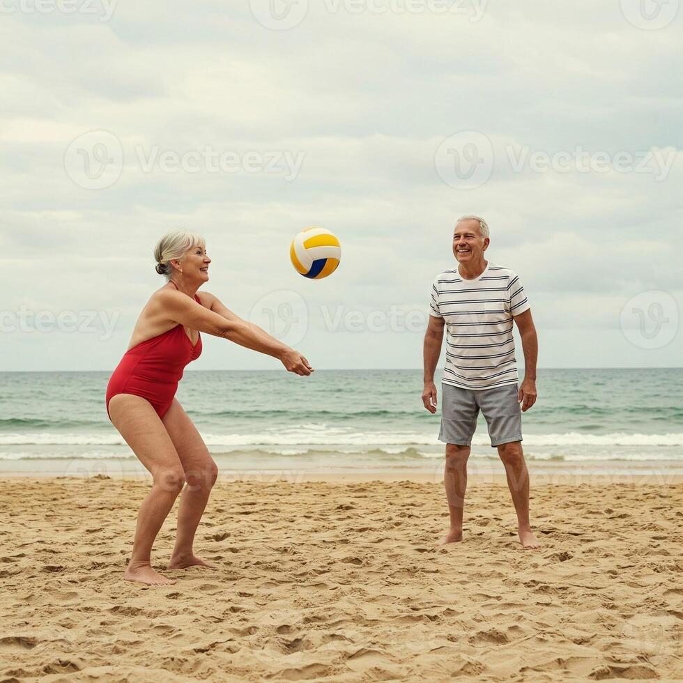 An older couple playing volleyball on the beach photo