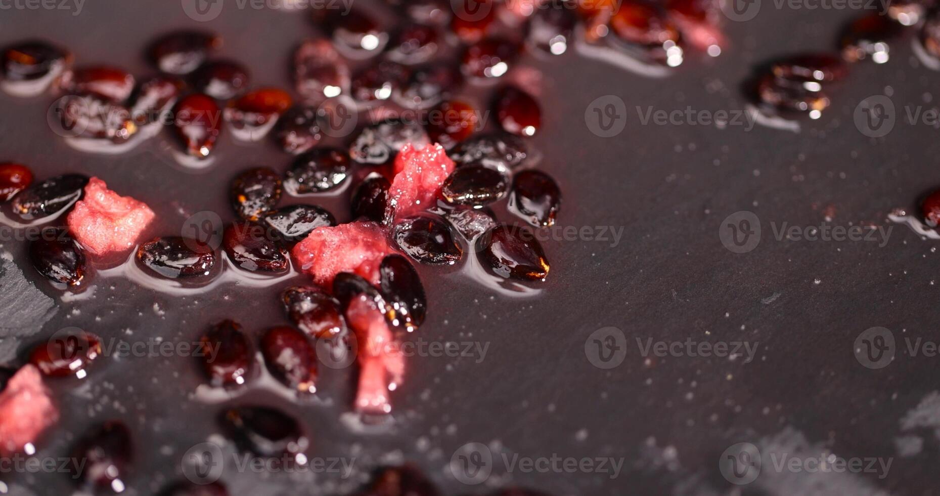 watermelon seeds and red pulp on black slate photo