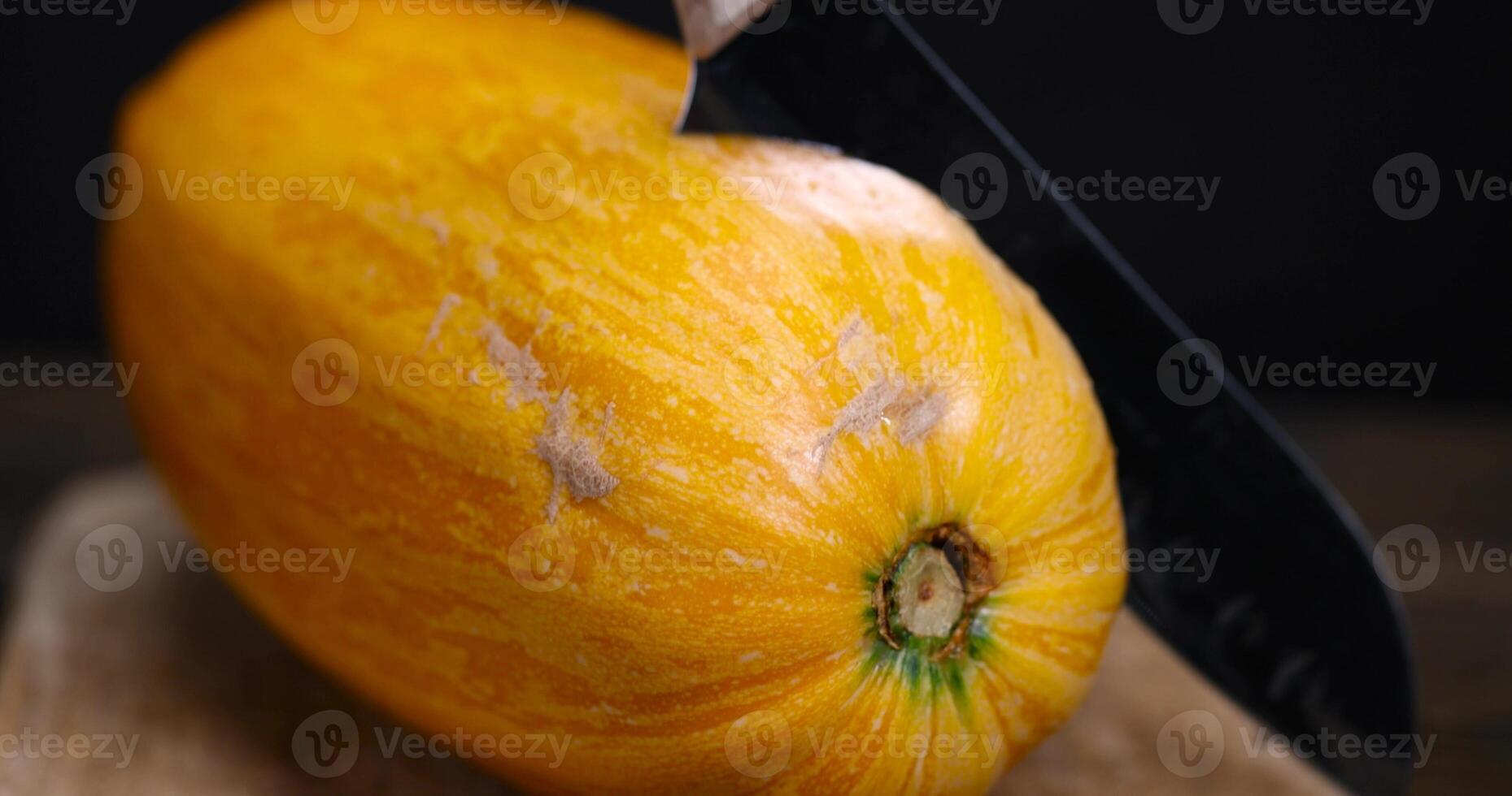 slicing ripe zucchini on a black cooking table photo