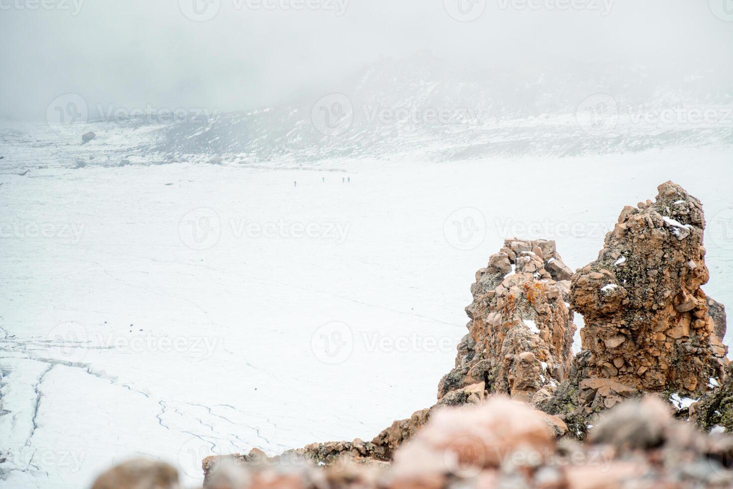 Aerial view climbers walk on Gergeti glacier tongue located on the southeastern slope of Mt. Kazbek. Kazbegi District of Georgia. Mount Kazbek climbing route. Caucasus mountain range snowy peaks photo