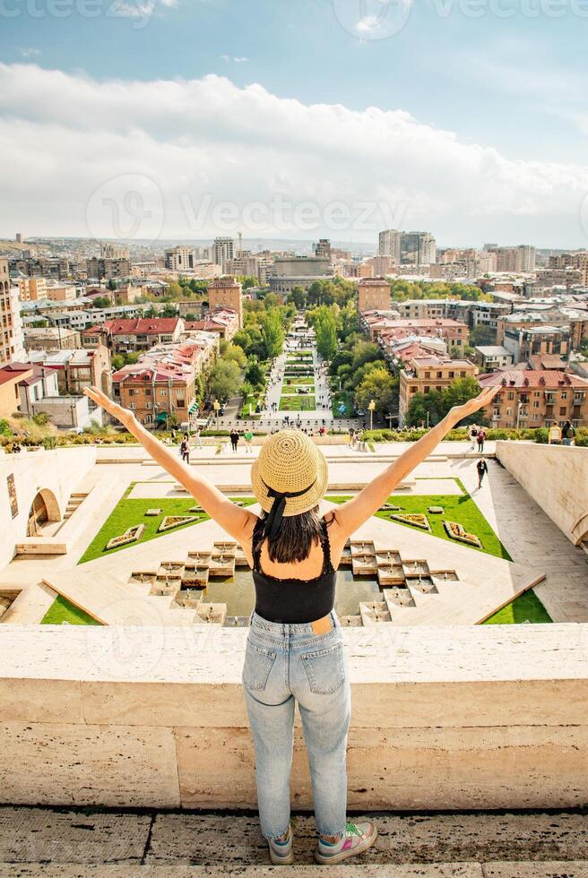 tourist girl enjoy cascade complex viewpoint with raised her hands and rejoices wonderful view of the main tourist attraction of Yerevan capital Armenia photo