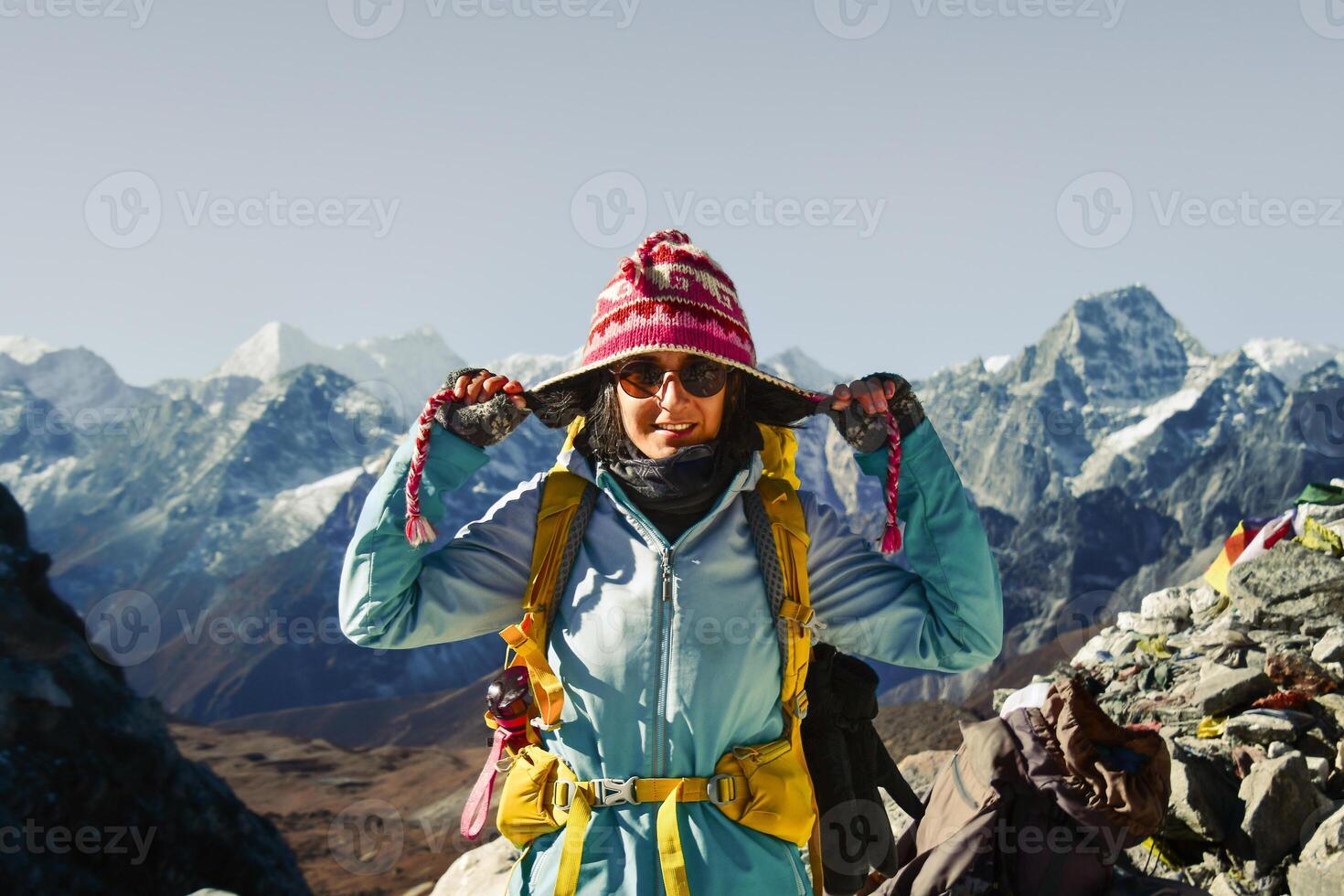 Close up front view caucasian woman portrait pose stand joyful on scenic viewpoint with Majestic Himalayas mountains background.Challenge achievement concept.Sunny trekking EBC photo
