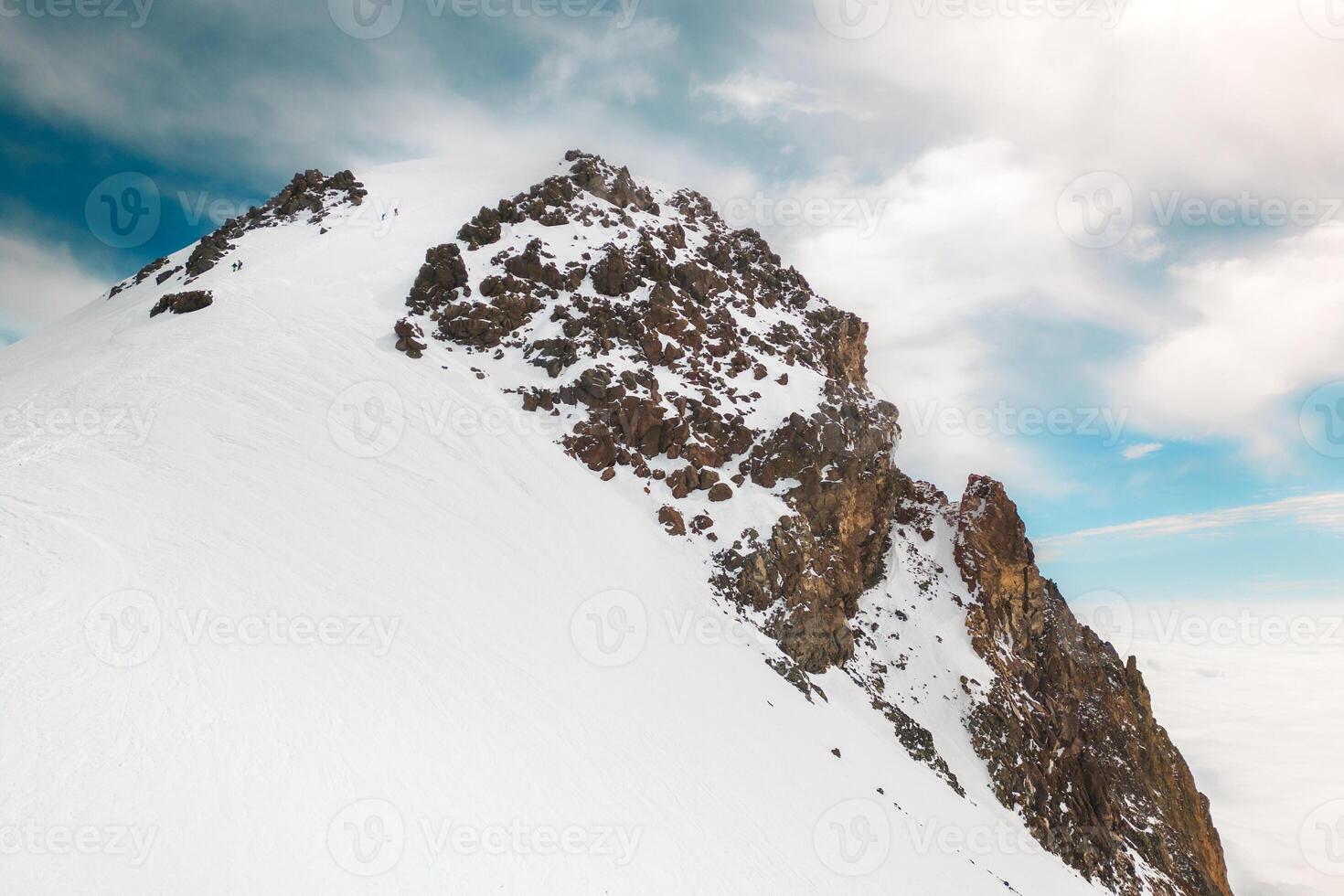 group of climbers two above clouds climb reaching famous Mount kazbek peak in Georgia. Mount Kazbek or Mount Kazbegi is dormant stratovolcano - major mountains of the Caucasus.Summit push photo