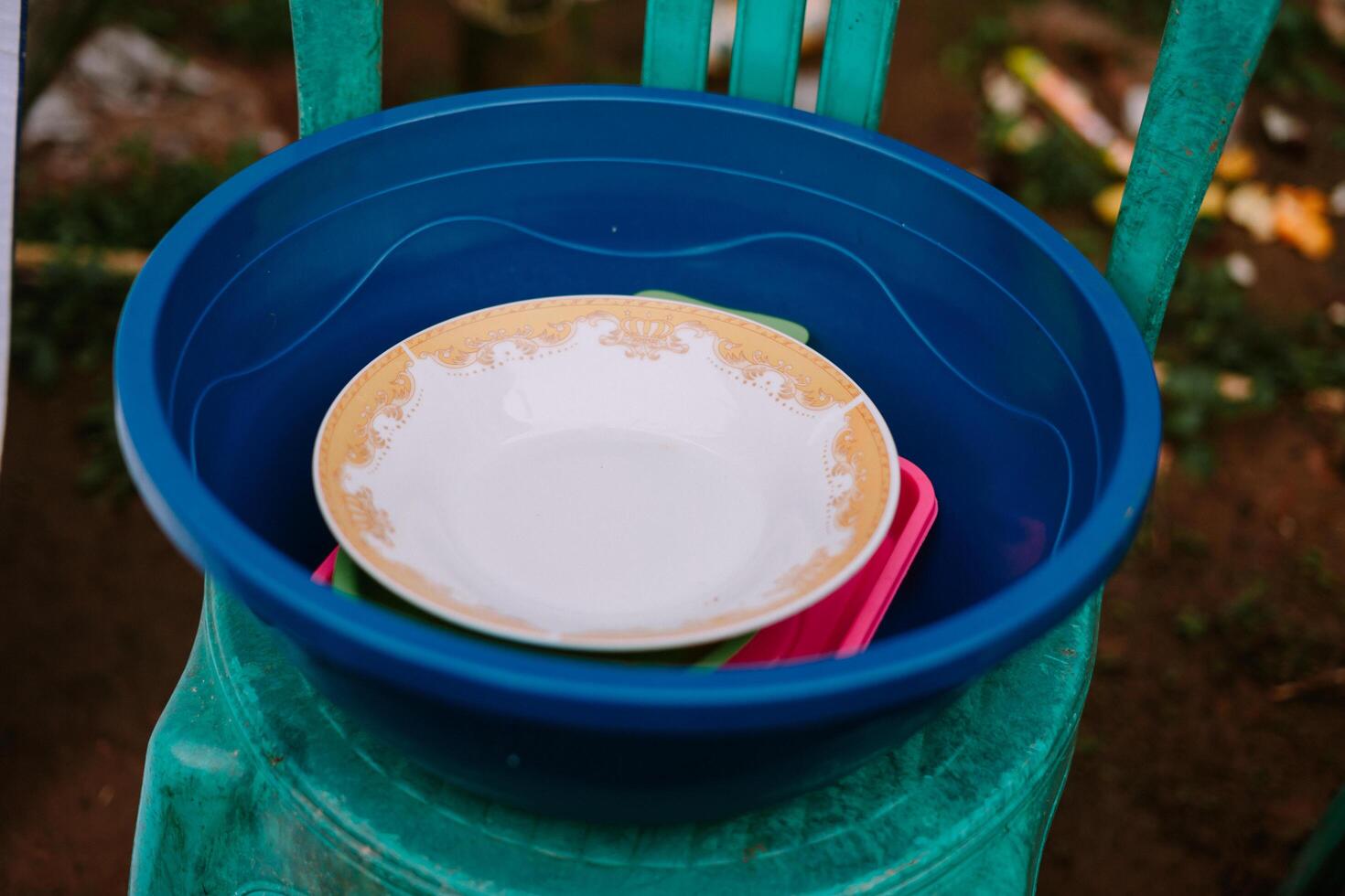 Rustic Still Life, Blue Tub with Dirty Dishes on a Green Chair photo