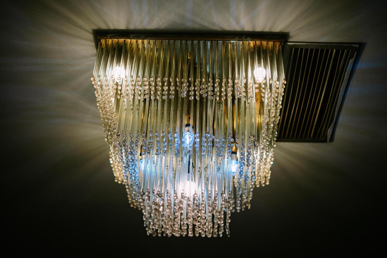 Elegant crystal chandelier illuminating a dimly lit room creating ambience photo
