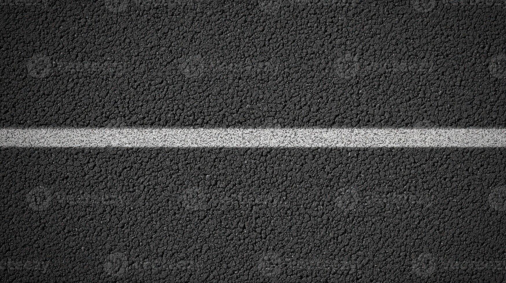 Close-up view of gray asphalt road with white divider line for urban concept photo