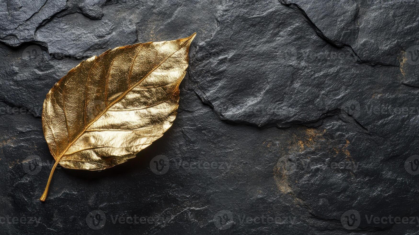 Golden leaf on dark slate surface symbolizing elegance and nature concept photo