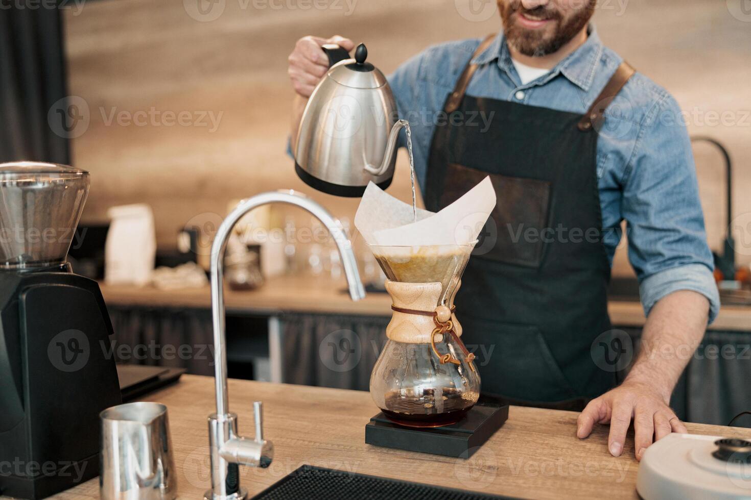 Close up of Barista pouring water on coffee ground with filter photo