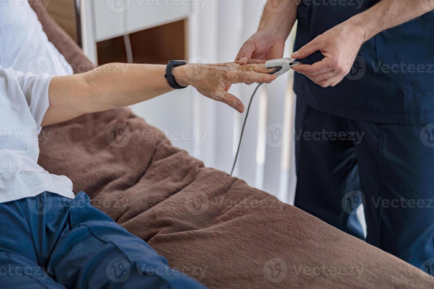 Nurse checking with fingertip pulse oximeter oxygen saturation of patient blood in hospital photo